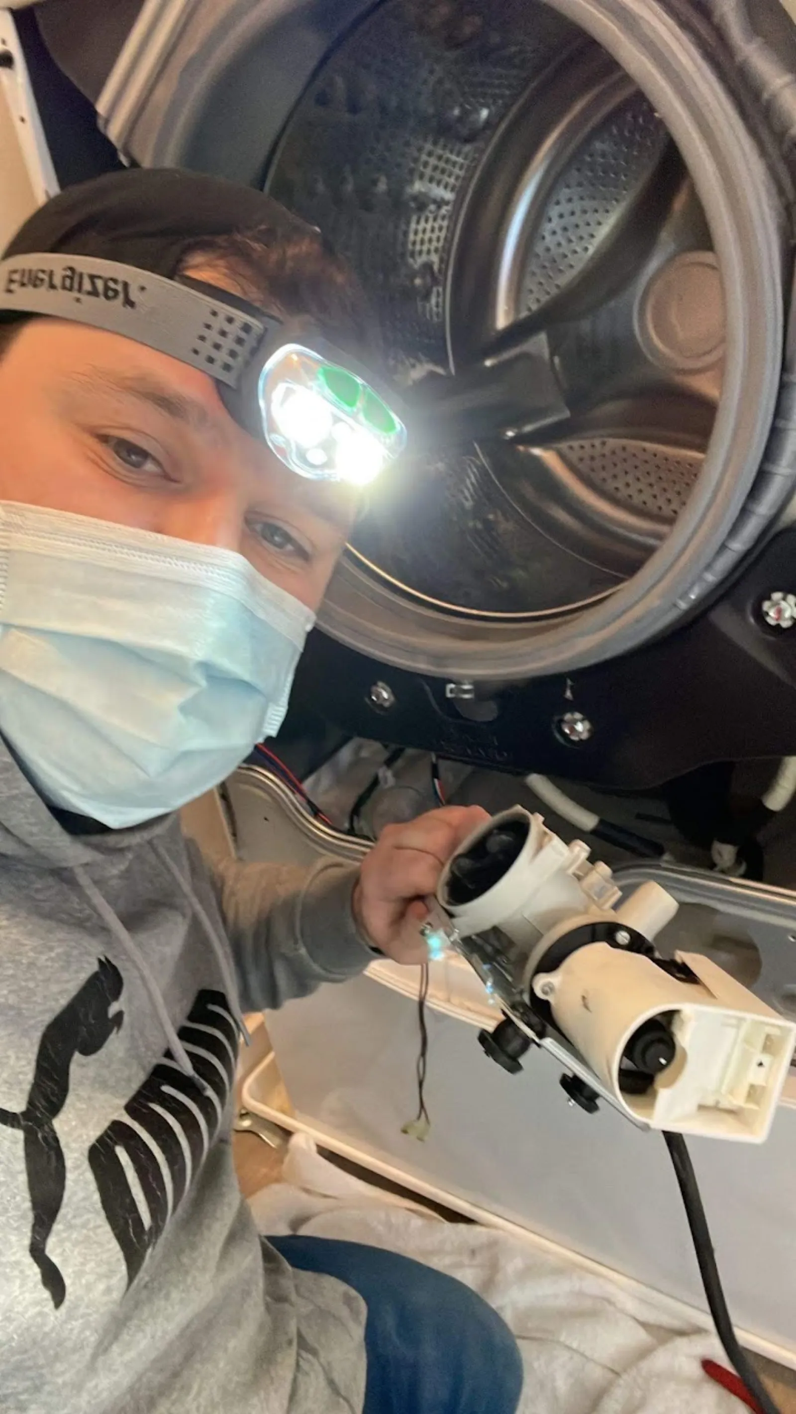 Technician repairing a washing machine that won't drain